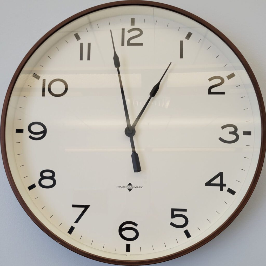Analog wooden wall clock displaying time as 1