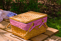 Large hand woven picnic basket tied with a pink ribbon