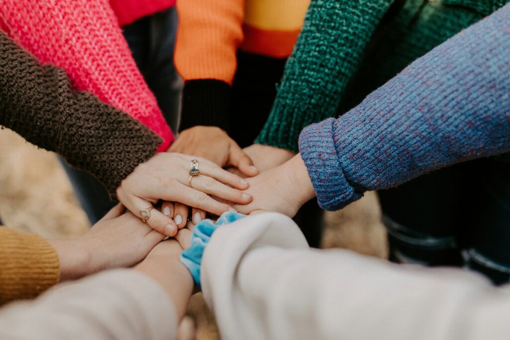 A group of people holding hands in the middle of a circle.